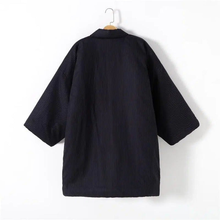 Kimono noir en velours côtelé suspendu, vêtement traditionnel japonais avec manches larges. Idéal pour un style décontracté ou élégant. Découvrez notre collection de kimonos uniques.