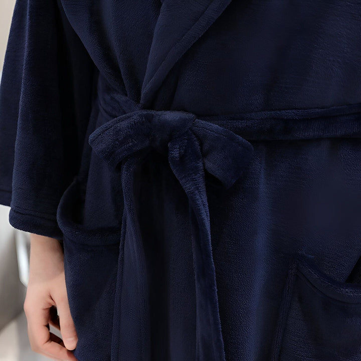 Détail d'un kimono en velours bleu marine avec ceinture nouée. Peignoir kimono doux et confortable. Vêtements de détente de luxe pour homme et femme.