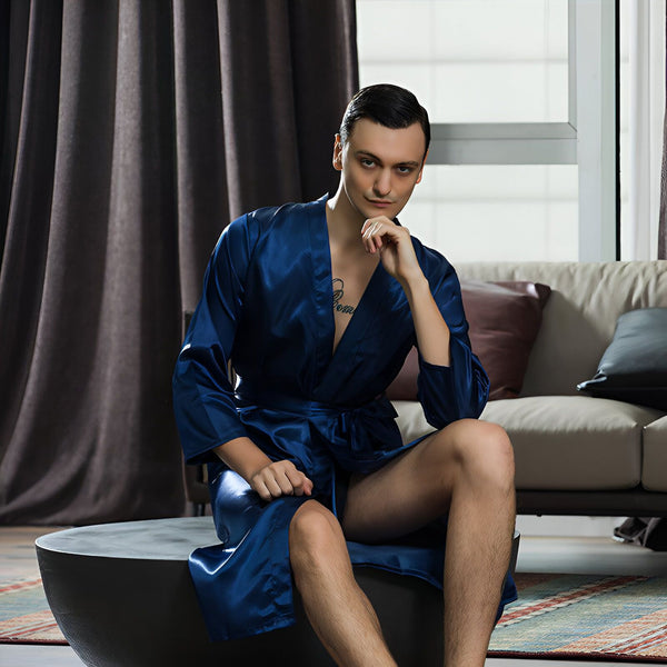 Homme assis portant un kimono bleu en soie. Élégance et confort pour vos moments de détente. Découvrez notre collection de kimonos.