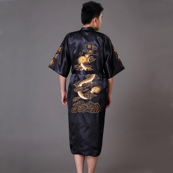 Homme portant un kimono noir avec motif dragon doré brodé. Vêtement de style japonais, idéal comme peignoir ou tenue d'intérieur. Découvrez notre collection de kimonos uniques.