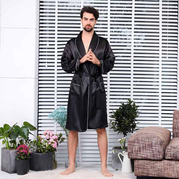 Homme portant un kimono noir élégant avec une ceinture assortie. Parfait comme vêtement de détente confortable. Découvrez notre collection de kimonos de luxe.