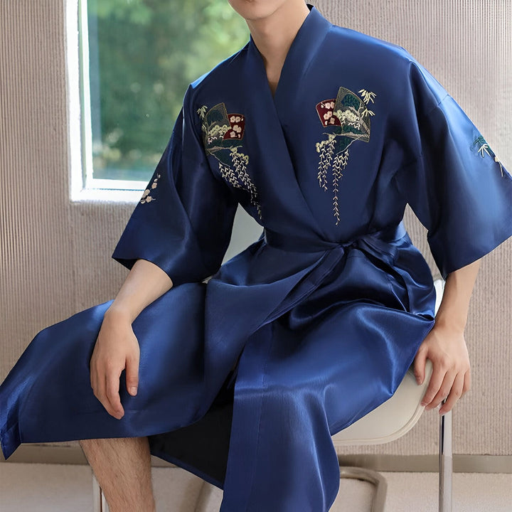 Homme portant un kimono bleu en soie avec broderies de motifs japonais traditionnels. Vente de kimonos pour hommes et femmes.