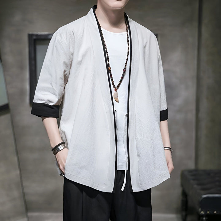 Homme portant un kimono blanc à manches 3/4 avec bordure noire. Vêtements japonais traditionnels et modernes. Découvrez notre collection de kimonos pour hommes.
