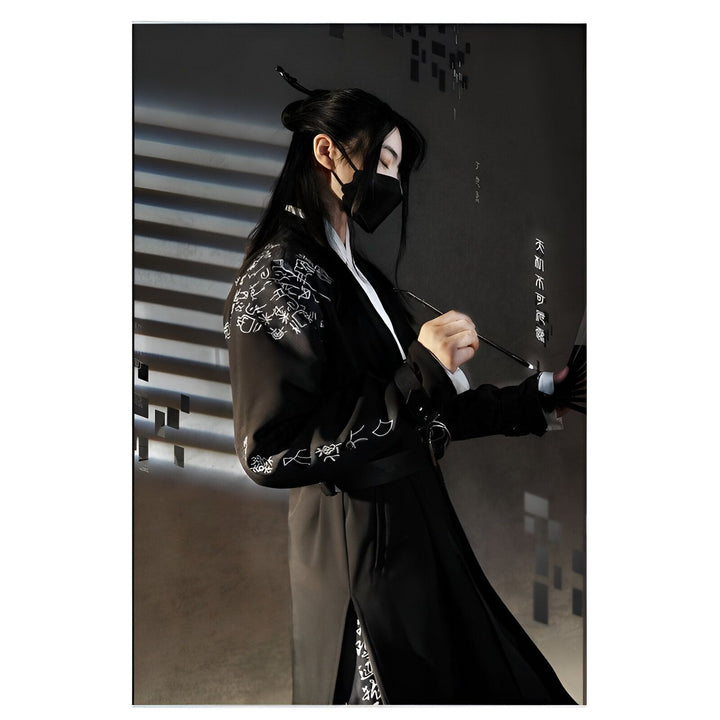 Homme en kimono noir avec motifs brodés blancs, masque noir et ombre de stores en fond. Vêtements traditionnels japonais, vente de kimonos en ligne.