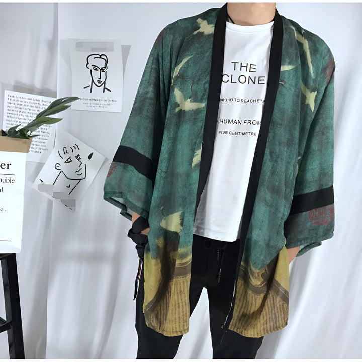 Homme portant un kimono vert à motifs d'oiseaux et de bâtiments. Vêtement japonais traditionnel, style décontracté. Notre collection de kimonos est parfaite pour toutes les occasions.