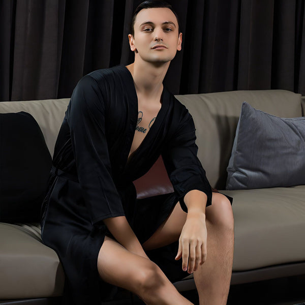 Homme portant un kimono noir élégant, assis sur un canapé. Kimonos de luxe pour hommes disponibles à l'achat.