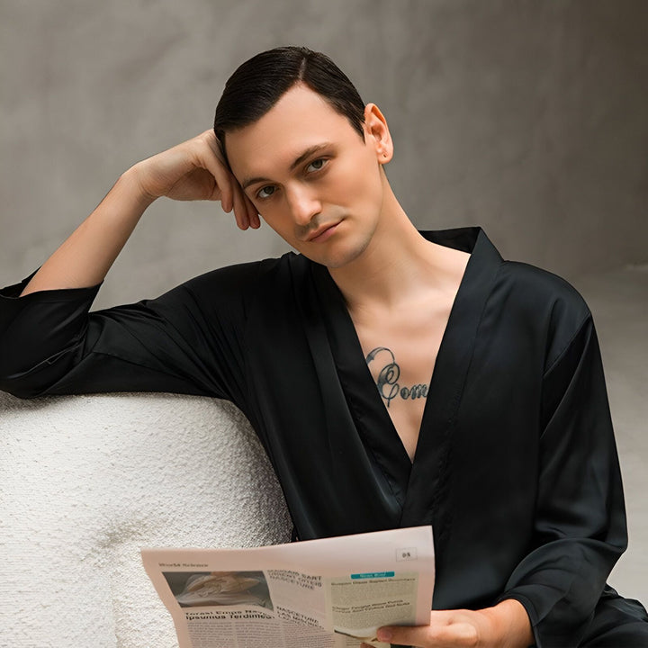 Homme portant un kimono noir élégant et lisant le journal. Kimonos pour hommes, confort et style. Découvrez notre collection de kimonos.