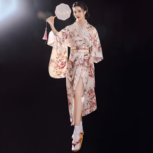 Femme portant un kimono fleuri avec éventail, kimono traditionnel japonais à motifs floraux, vente de kimonos en ligne.