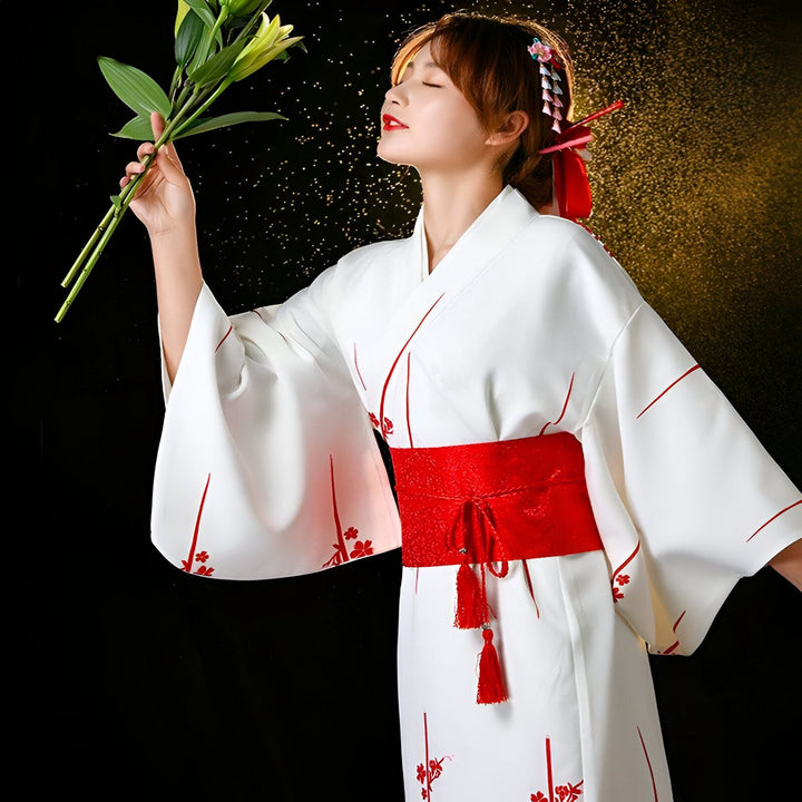 Femme en kimono blanc avec obi rouge, tenant des fleurs. Vêtements traditionnels japonais à vendre.