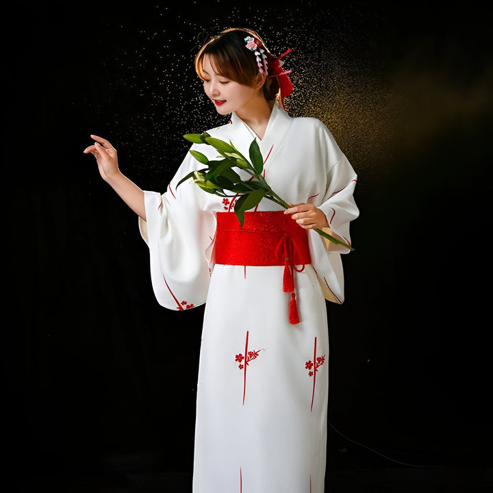 Femme en kimono blanc avec ceinture rouge, tenant des fleurs. Vêtements traditionnels japonais. Kimonos à vendre.