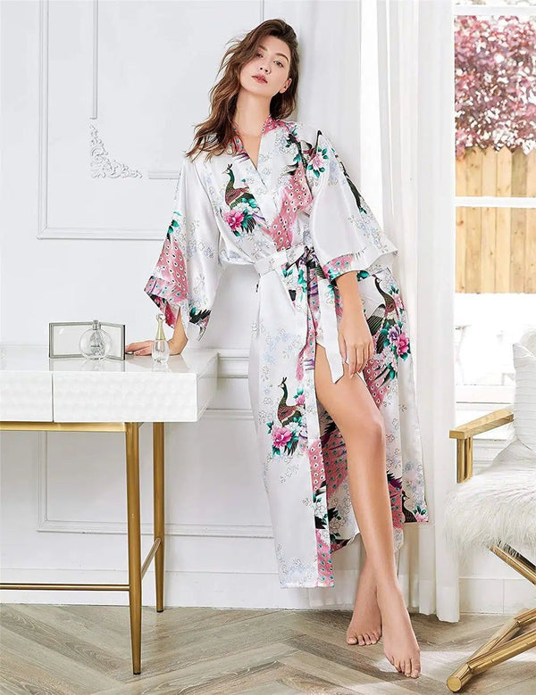 Femme portant un kimono blanc à motifs de paons roses et verts. Vente de kimonos pour femmes. Kimono en soie confortable et élégant.