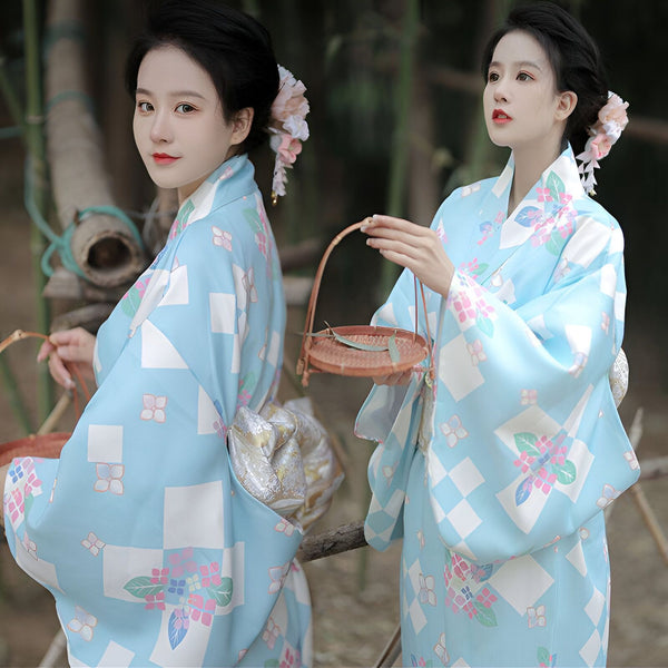 Femmes en kimonos bleus à motifs floraux. Kimonos traditionnels japonais en vente. Accessoires cheveux floraux. Style élégant et raffiné.