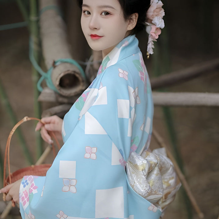 Femme portant un kimono bleu à motifs floraux. Kimonos traditionnels à vendre.