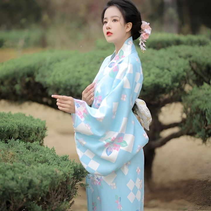 Jeune femme portant un kimono japonais bleu ciel avec motifs floraux. Vêtements traditionnels japonais. Mode kimono féminin. Boutique de kimonos en ligne.