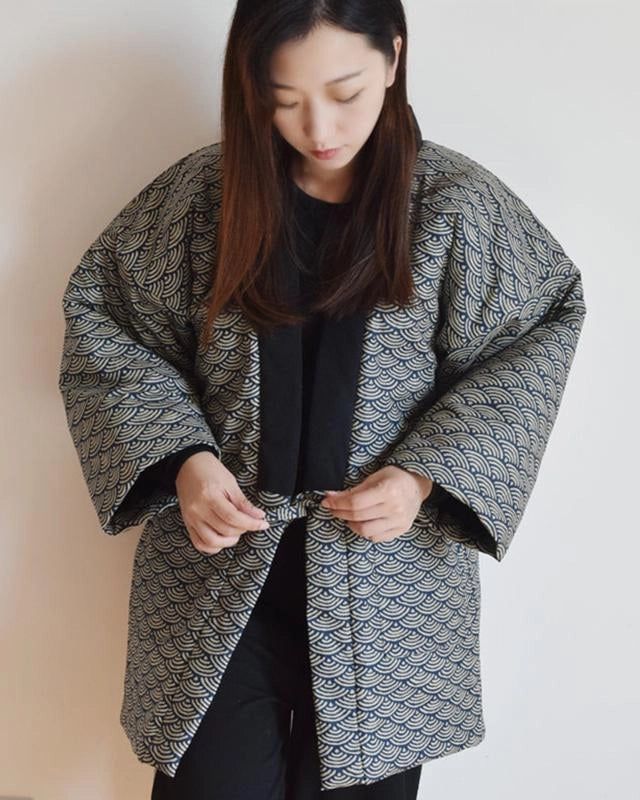 Femme asiatique portant un kimono à motifs vagues bleus et beige. Vente de kimonos pour femmes, style japonais traditionnel et moderne.