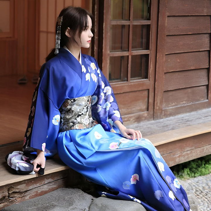 Femme assise portant un kimono bleu fleuri avec obi. Vêtements traditionnels japonais. Produits kimono disponibles à l'achat.