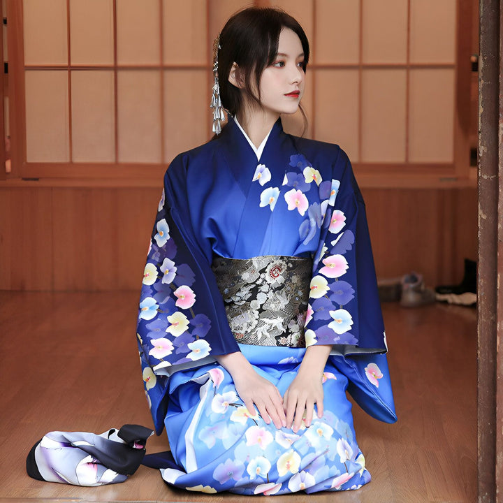 Femme en kimono bleu à motifs floraux, agenouillée. Kimono traditionnel japonais à vendre.