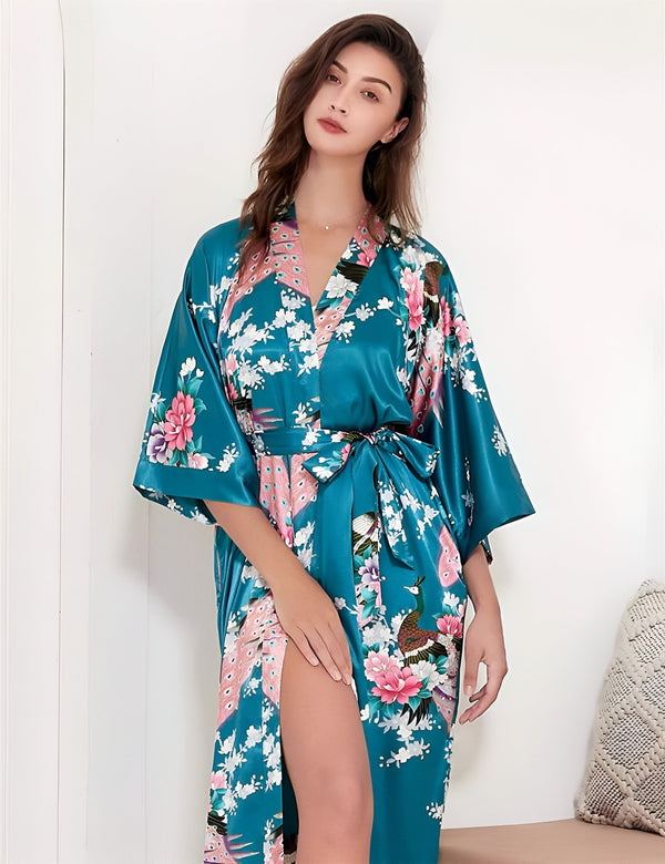 Femme portant un kimono en satin bleu turquoise avec motifs floraux et paons roses. Kimono de notre boutique en ligne.