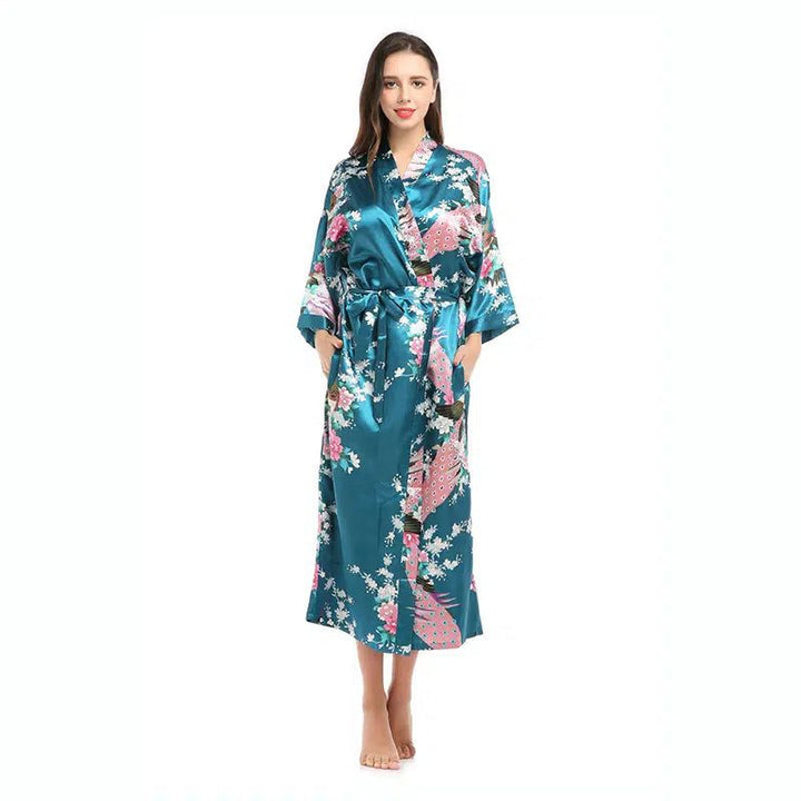 Femme portant un kimono bleu turquoise avec des motifs floraux et de paons. Kimono long avec ceinture. Vêtements de détente.