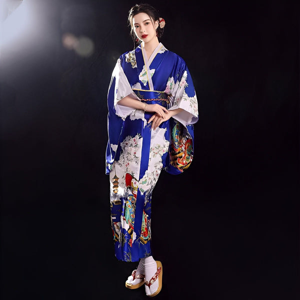 Femme portant un kimono japonais traditionnel bleu et blanc avec des motifs floraux et des personnages. Vente de kimonos authentiques.