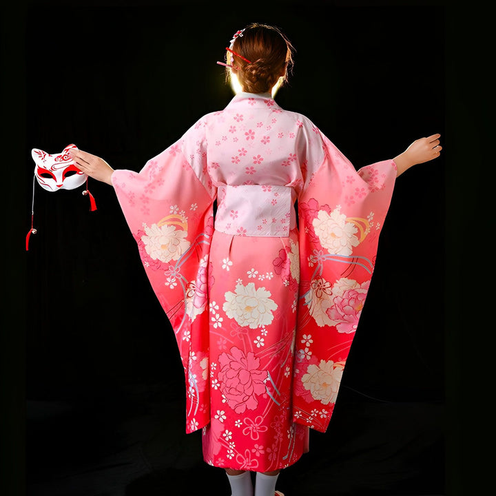 Femme vue de dos portant un kimono rose à motifs floraux, tenant un masque de renard. Vêtements traditionnels japonais en vente.