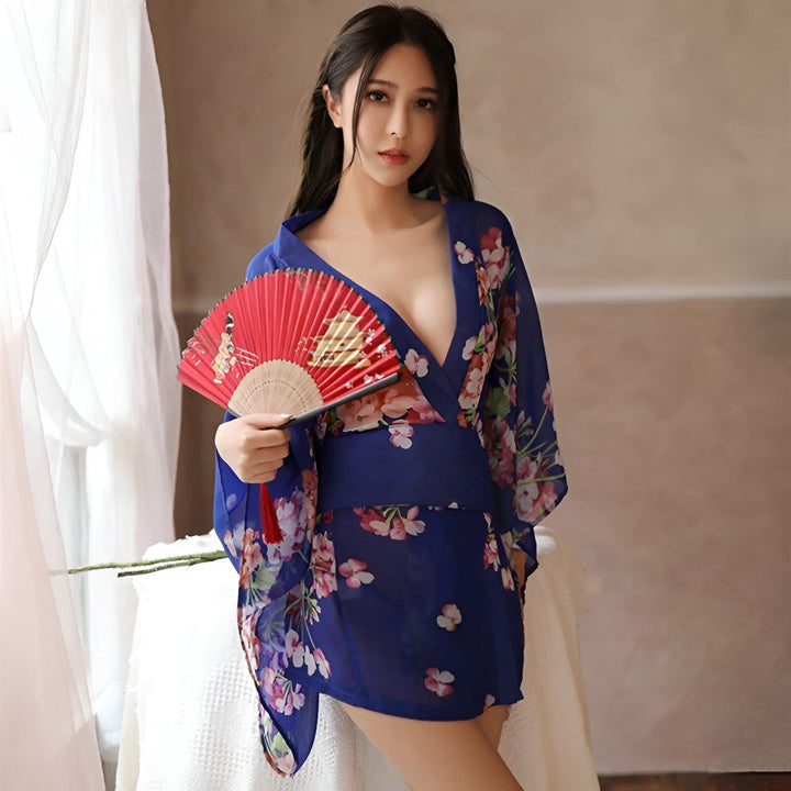 Femme portant un kimono bleu fleuri et tenant un éventail rouge. Kimonos disponibles à l'achat.