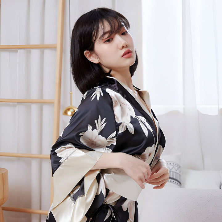 Femme portant un kimono noir à motifs floraux. Kimono élégant et confortable, idéal pour se détendre à la maison. Découvrez notre collection de kimonos de qualité.