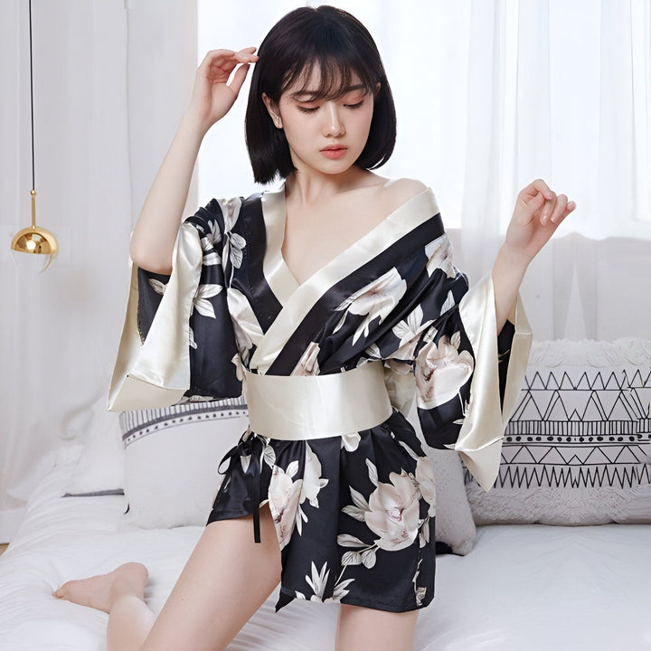 Femme portant un kimono court noir à fleurs. Kimonos pour femmes, vêtements de nuit japonais traditionnels. Boutique en ligne de kimonos.