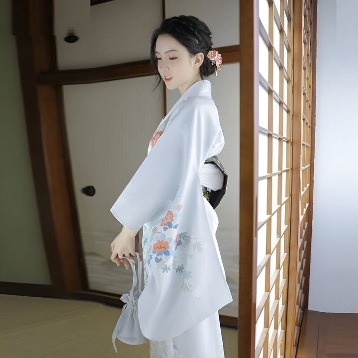 Femme portant un kimono bleu clair avec motifs floraux. Vente de kimonos traditionnels japonais. Détails soignés et élégance. Accessoire de cheveux floral. Mode japonaise authentique.