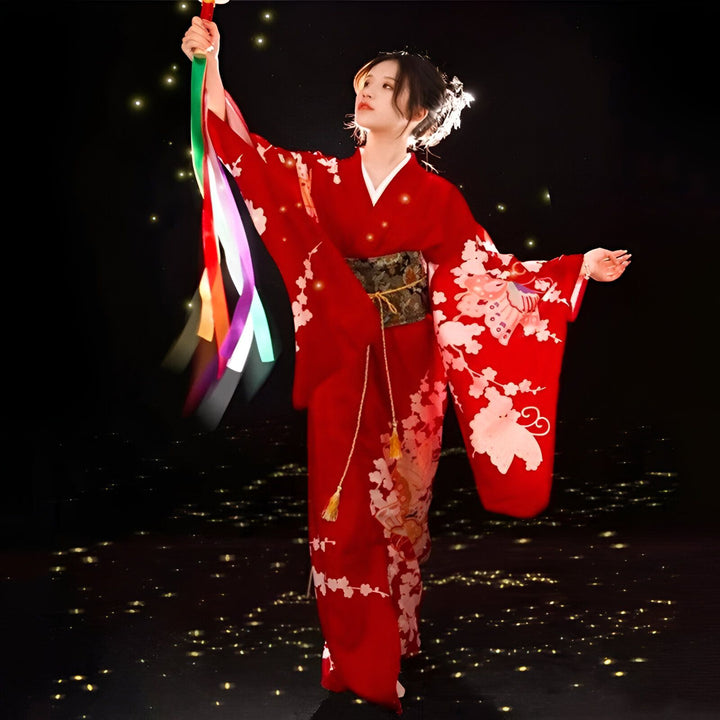 Femme en kimono rouge orné de motifs floraux et de papillons. Elle tient des rubans colorés. Kimonos traditionnels japonais à vendre.