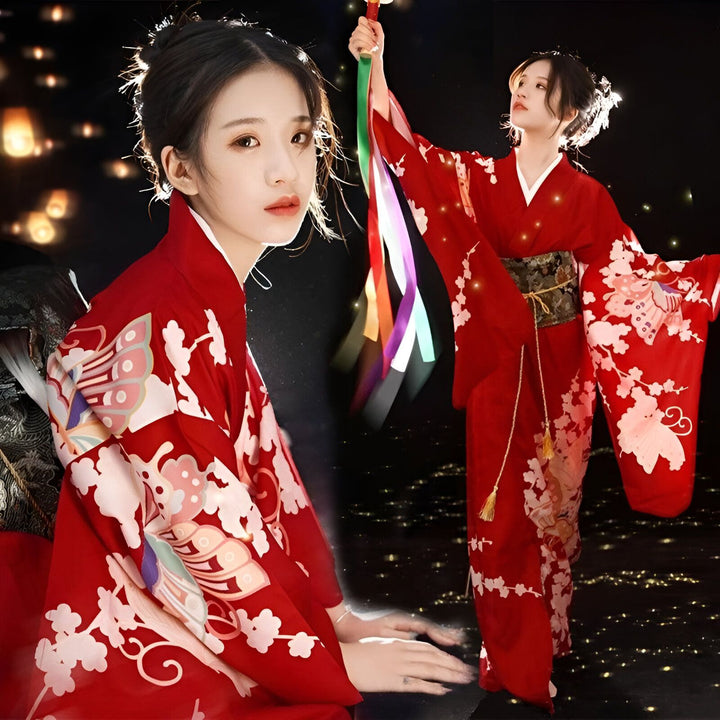 Femme portant un kimono rouge traditionnel avec motifs floraux blancs et ceinture obi. Elle tient des rubans colorés. Kimonos japonais en vente.