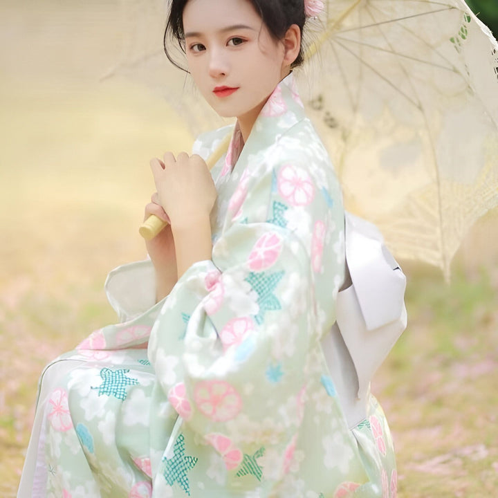 Jeune femme en kimono fleuri pastel avec un parapluie. Kimonos traditionnels et modernes à vendre.