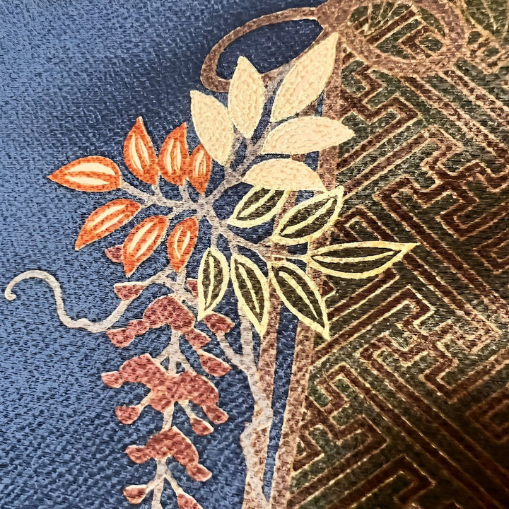 Motifs floraux japonais brodés sur kimono. Détail de feuilles aux couleurs automnales et motif géométrique traditionnel. Tissus et textures raffinés. Vêtements japonais authentiques.