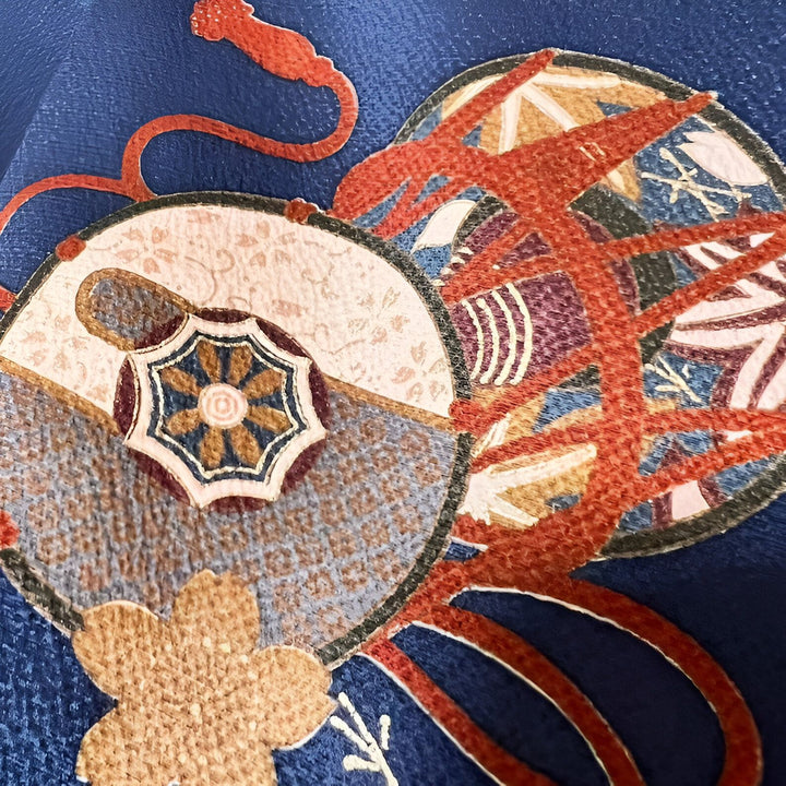Motifs traditionnels japonais brodés sur tissu bleu, détails de kimono de notre collection. Cercles décorés et cordons rouges.