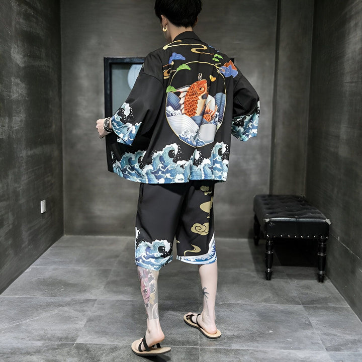 Homme portant un kimono noir imprimé avec un motif de carpe koï et de vagues, faisant partie d'un ensemble kimono. Vêtements japonais traditionnels revisités, vente en ligne.