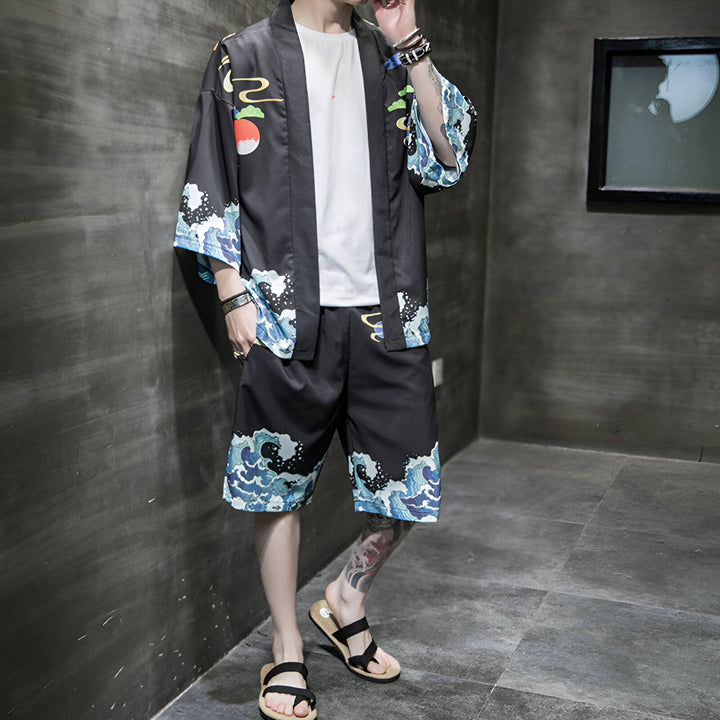 Homme portant un kimono noir et un short assorti, motif vagues bleues et blanches. Vêtements de style japonais, vente de kimonos en ligne.