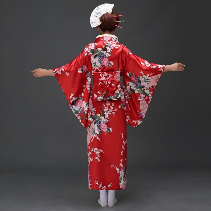 Femme de dos portant un kimono rouge à motifs floraux, coiffure ornée d'un éventail. Vêtements traditionnels japonais, vente de kimonos en ligne.