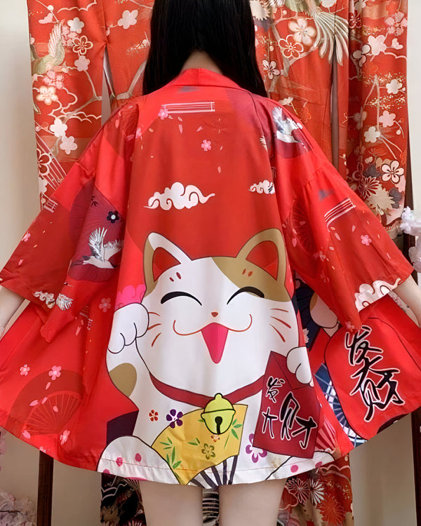 Dos d'une personne portant un kimono rouge avec un motif de chat porte-bonheur Maneki Neko et des nuages blancs. Motif floral japonais traditionnel en arrière-plan. Kimono japonais disponible à l'achat.