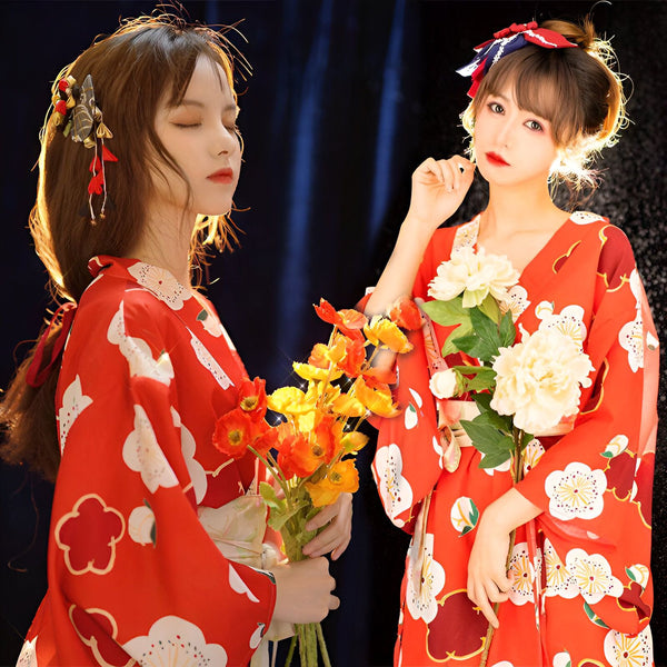Deux femmes en kimonos rouges traditionnels avec motifs floraux blancs. Elles tiennent des fleurs. Accessoires cheveux assortis. Vente de kimonos en ligne.