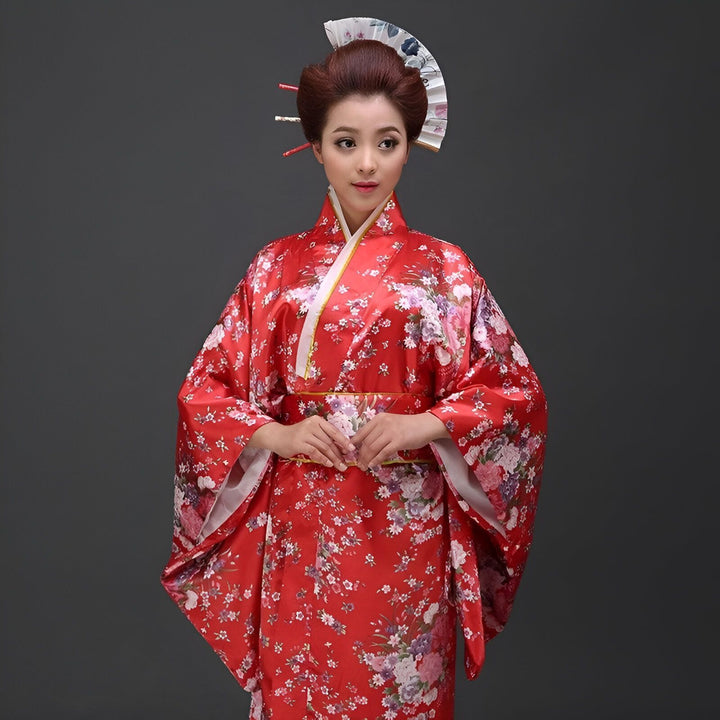 Femme portant un kimono rouge traditionnel à motifs floraux. Vente de kimonos authentiques en ligne.