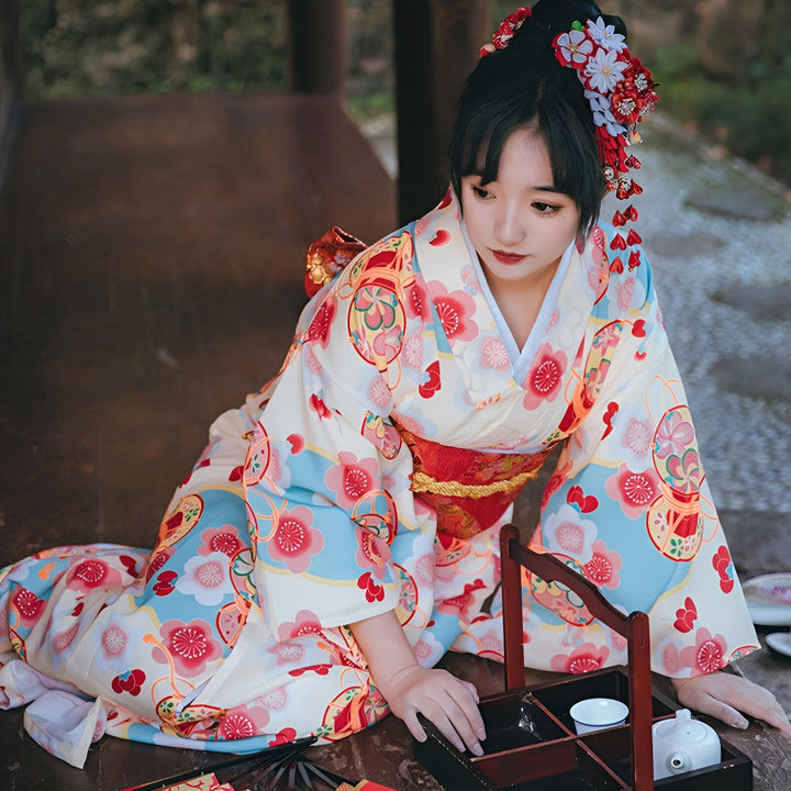 Femme asiatique en kimono traditionnel à motifs floraux. Coiffure ornée de fleurs. Vente de kimonos authentiques.