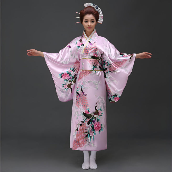 Femme portant un kimono rose à motifs de paons et de fleurs, coiffée d'ornements traditionnels. Costume japonais.