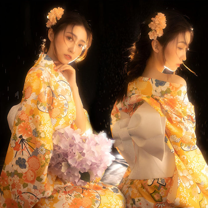 Deux femmes portant des kimonos jaunes à motifs floraux, avec des fleurs dans les cheveux. Kimonos traditionnels japonais en vente.