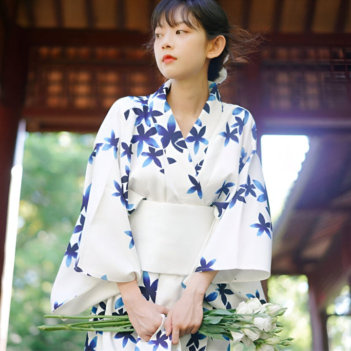 Jeune femme portant un kimono blanc à motifs floraux bleus. Kimono traditionnel japonais en vente.