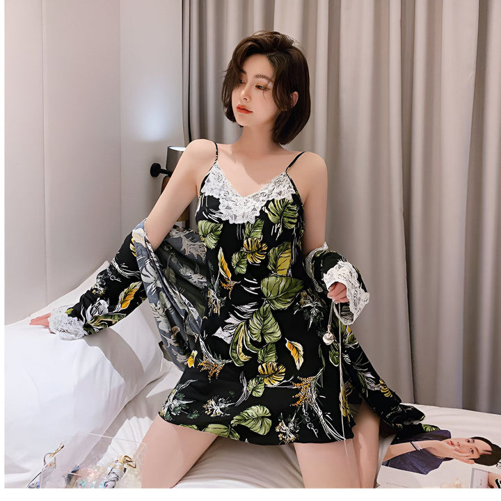Femme portant un kimono noir à motifs floraux verts et jaunes avec garniture en dentelle blanche. Ensemble de nuit kimono confortable et élégant.