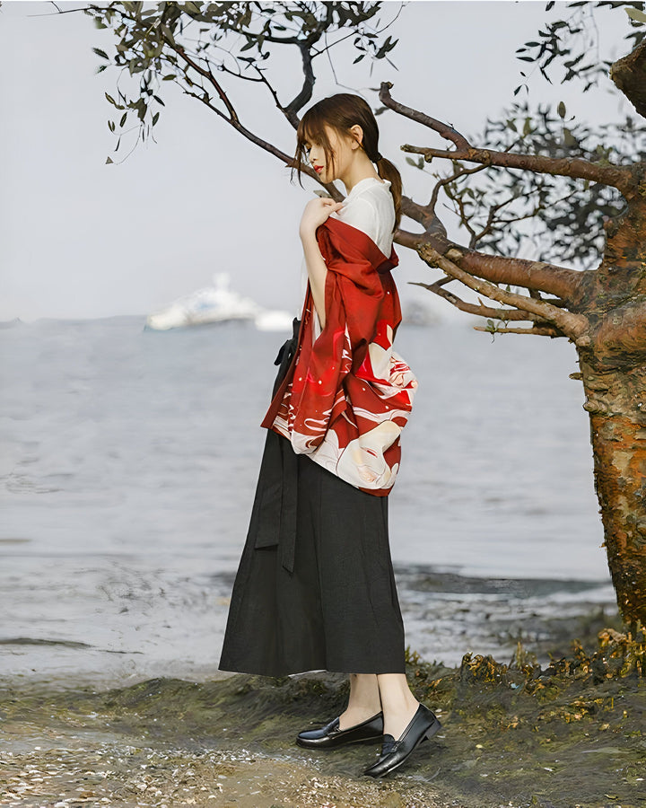 Femme portant un kimono rouge imprimé sur une plage. Vente de kimonos traditionnels et modernes pour femmes. Style japonais élégant.