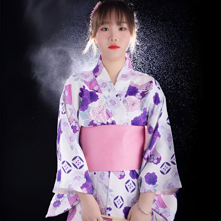 Jeune femme en kimono fleuri blanc et violet, ceinture obi rose. Kimonos japonais traditionnels à vendre.