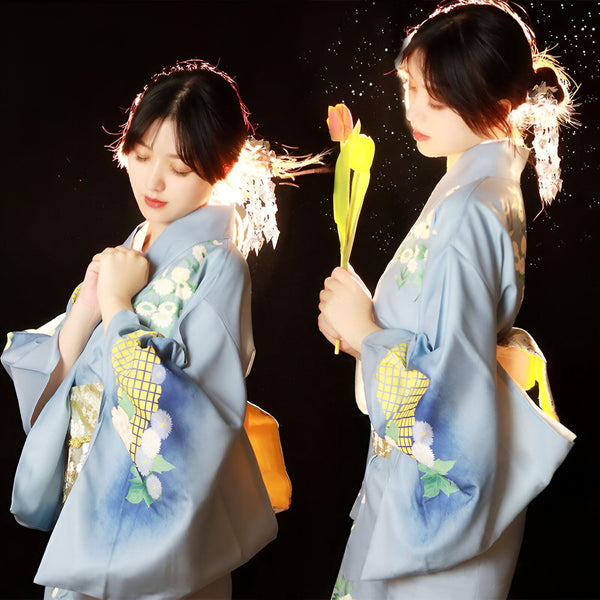 Deux jeunes femmes portant des kimonos bleus à motifs floraux. Elles tiennent des tulipes. Kimonos traditionnels japonais en vente.
