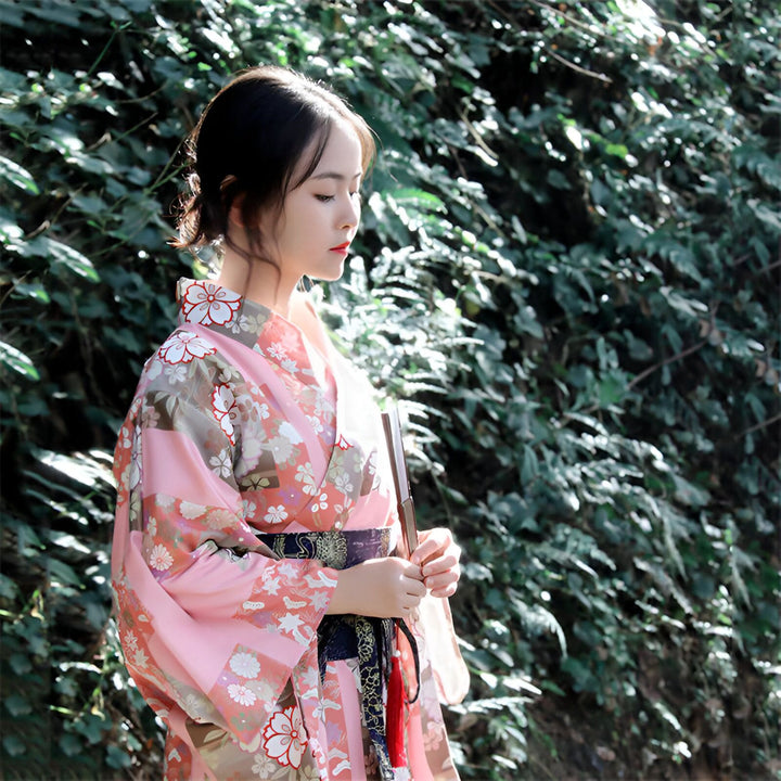 Femme portant un kimono rose à motifs floraux. Kimono traditionnel japonais à vendre. Élégance et style japonais.
