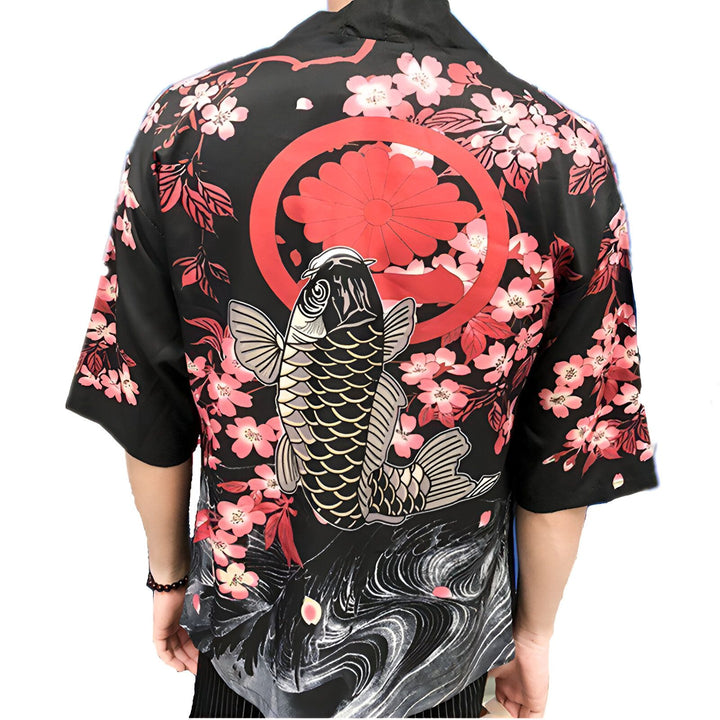 Dos d'une personne portant un kimono noir avec un motif de carpe koï, des fleurs de cerisier roses et un chrysanthème rouge. Vêtements japonais traditionnels. Boutique de kimonos en ligne.